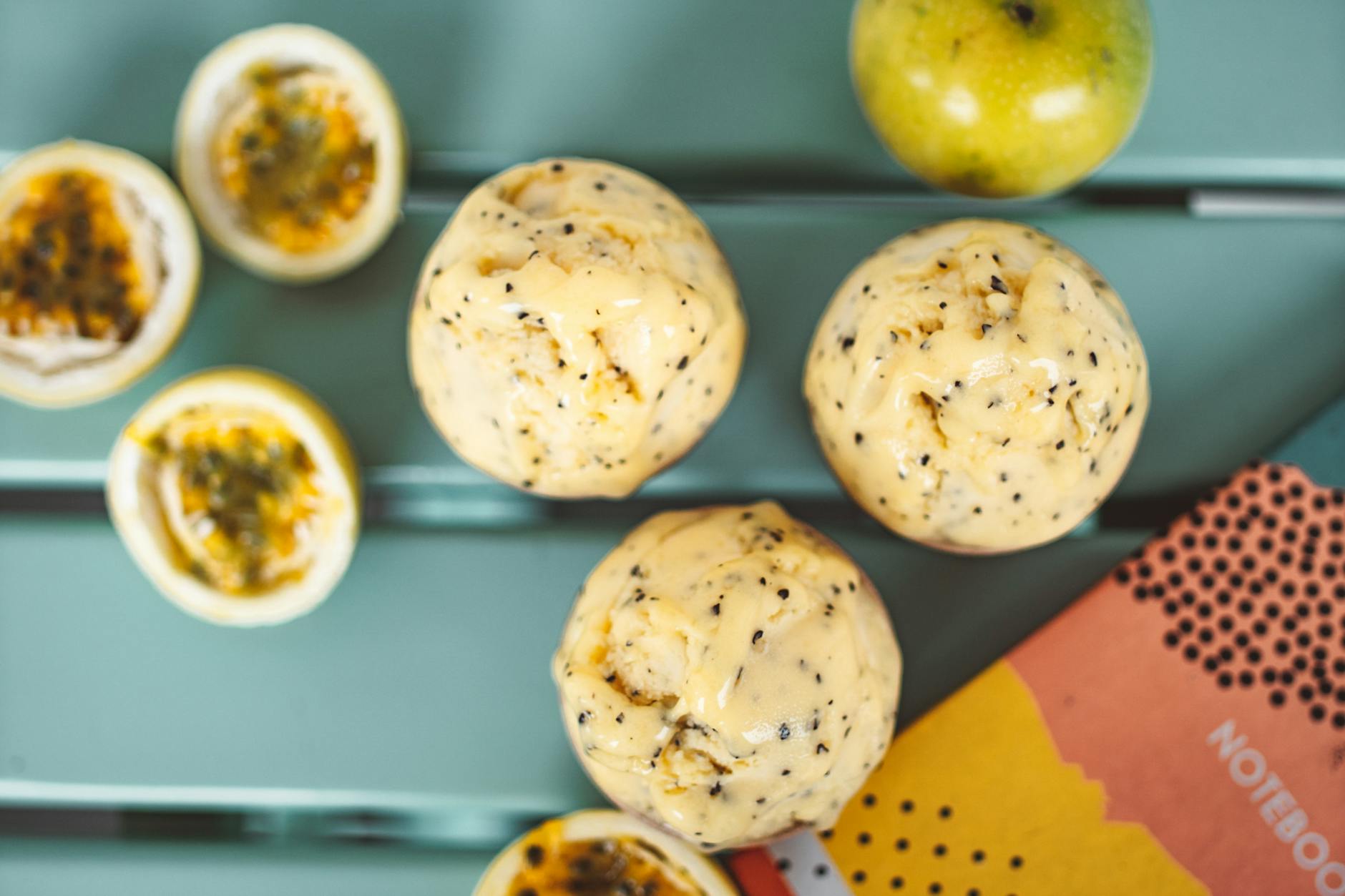 Kule sorbetu z marakui i świeże owoce na turkusowym tle