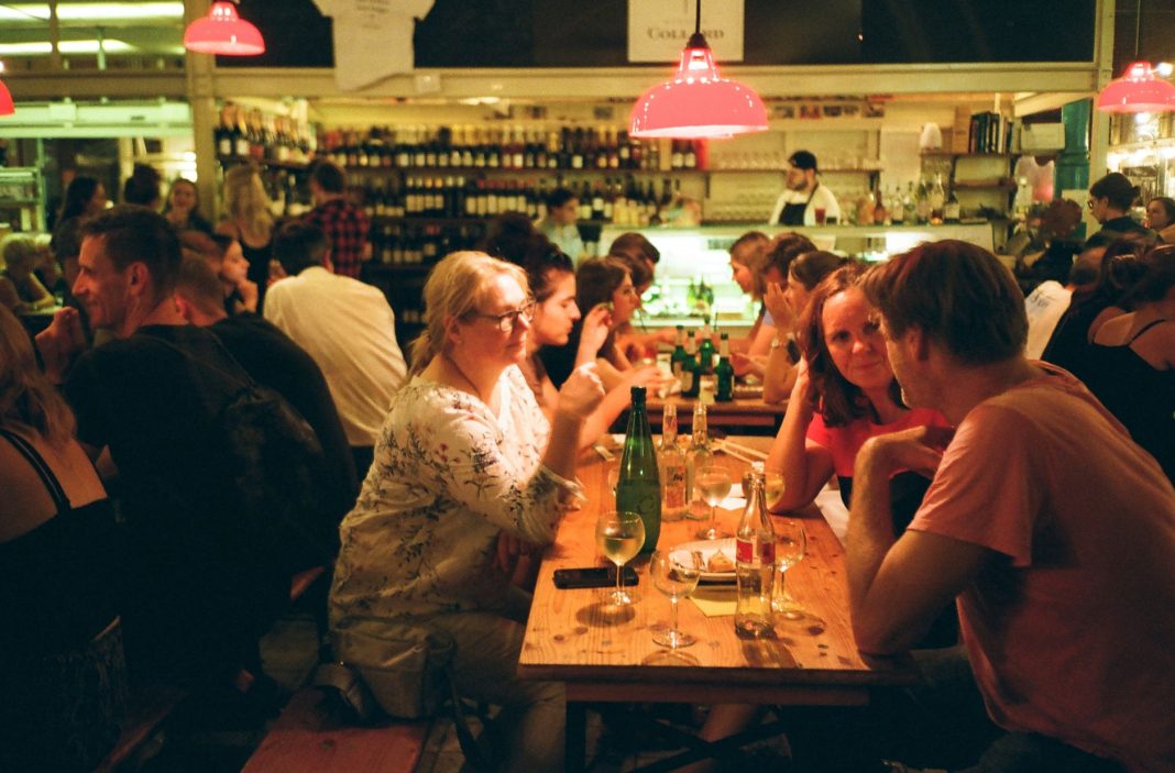 Goście rozmawiający przy drinkach w tętniącej życiem restauracji Goście rozmawiający przy drinkach w tętniącej życiem restauracji